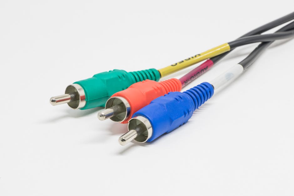 Close-up of red, green, and blue RCA connectors on a white surface, capturing vibrant color contrast.