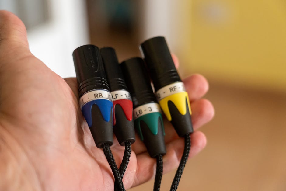 Close-up of colorful audio cables in a human hand, perfect for tech and electronics themes.