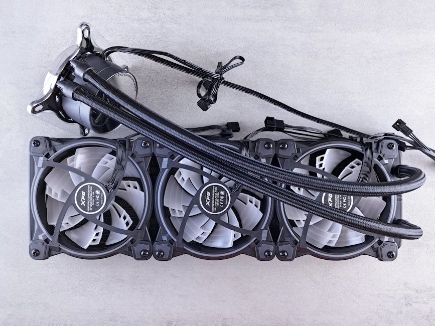 Top view of a triple radiator cooling system with fans for computer hardware in a minimalist gray setting.