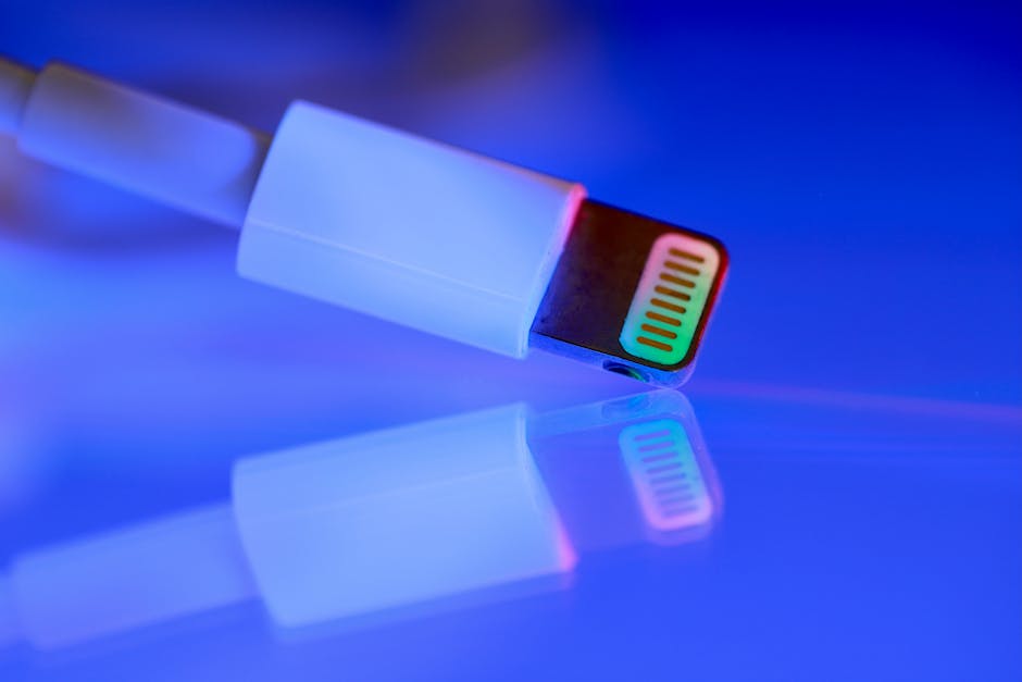 A close-up of a USB cable with colorful reflections on a shiny surface, emphasizing technology and connectivity.