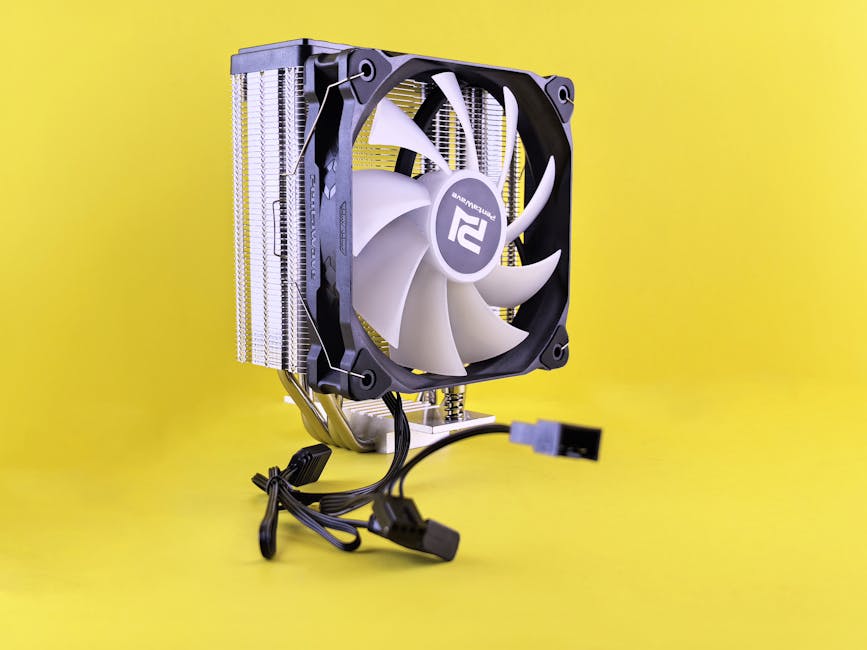 PC cooling fan with heatsink and cable against a bright yellow backdrop. PC cooling fan with heatsink and cable against a bright yellow backdrop.