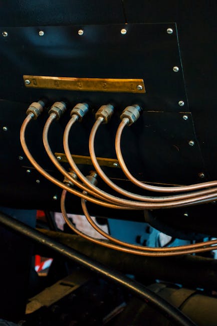 Detailed view of metal hoses and connectors in an industrial setting for engineering concepts.