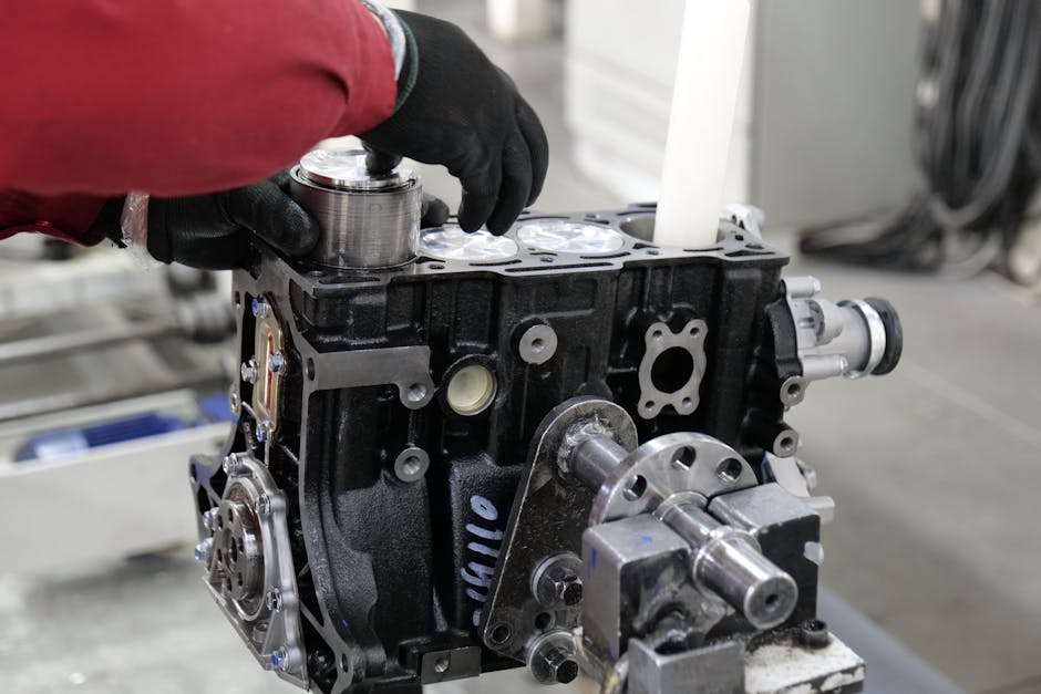 Mechanic working on engine assembly in a workshop, focusing on precision and craftsmanship. Mechanic working on engine assembly in a workshop, focusing on precision and craftsmanship.