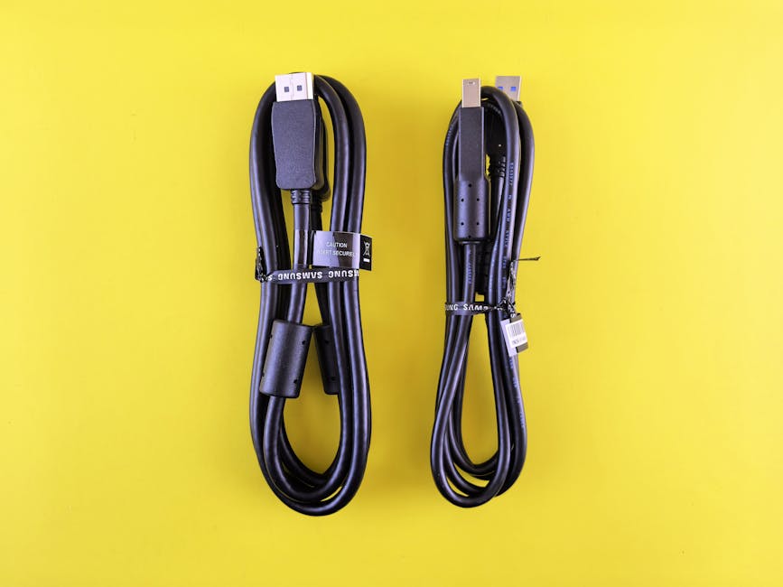 Pair of black Samsung USB cables neatly arranged on a vibrant yellow surface.