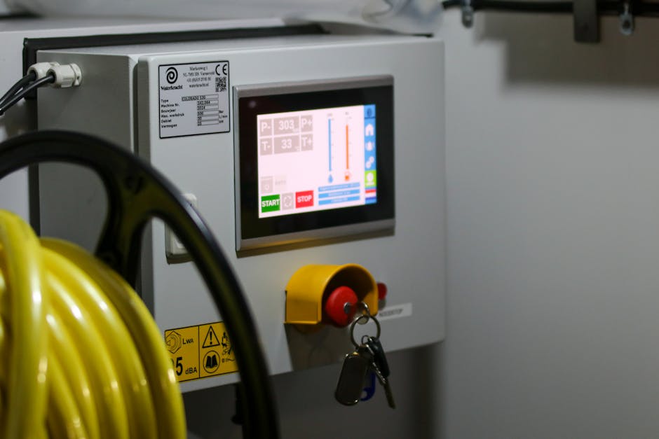 Close-up of an industrial control panel displaying safety features and a digital screen. Close-up of an industrial control panel displaying safety features and a digital screen.