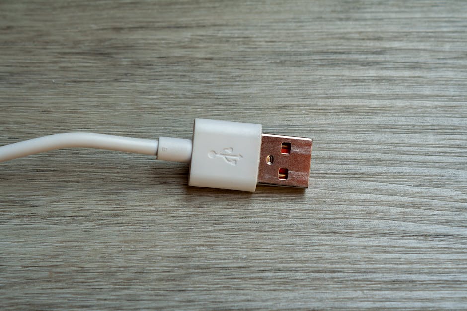 A detailed close-up of a white USB cable connector placed on a wooden surface.