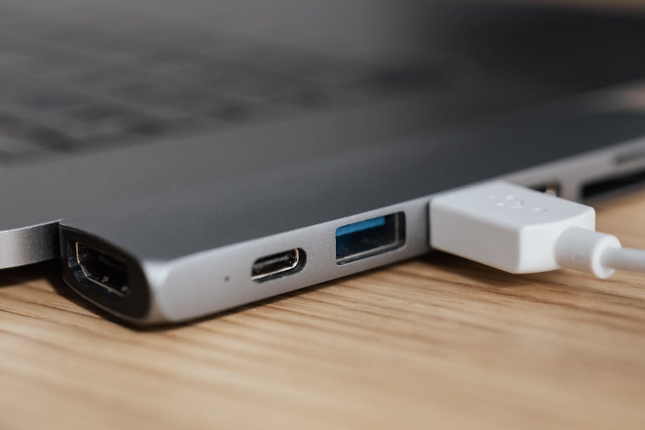 USB type c multiport adapter with plugged white cable connected to modern laptop USB type c multiport adapter with plugged white cable connected to modern laptop
