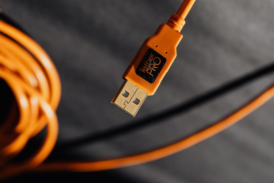 Macro shot of an orange TetherPro USB cable with high detail and shallow focus.