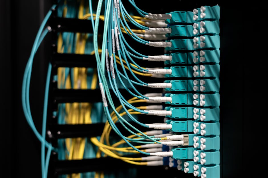 Close-up view of neatly arranged fiber optic cables in a patch panel for efficient data management. Close-up view of neatly arranged fiber optic cables in a patch panel for efficient data management.