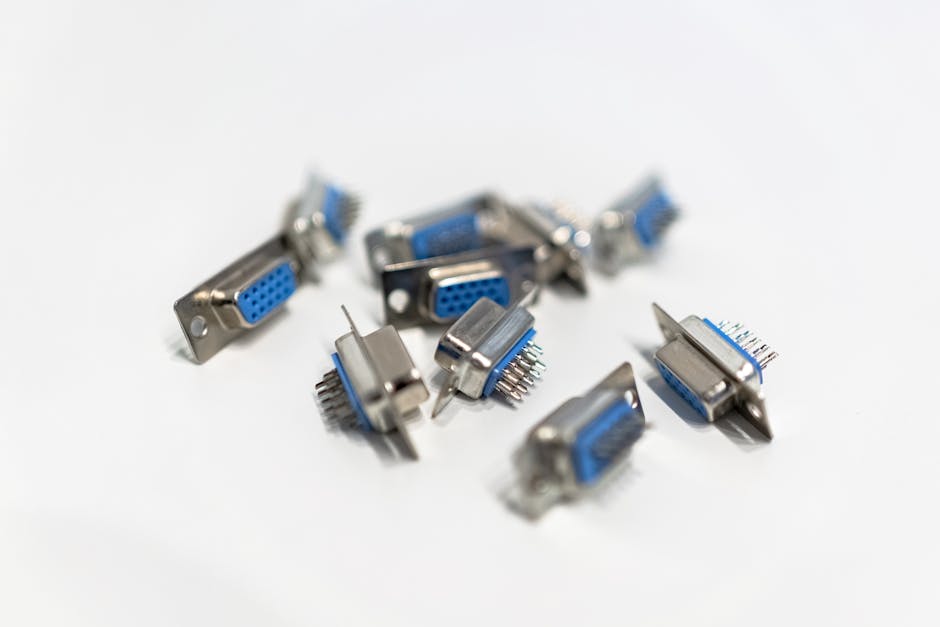 A close-up view of blue VGA connectors scattered on a white surface, highlighting hardware details.
