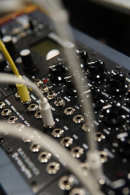 Detailed view of an audio mixer with cables connected, showcasing electronic controls.