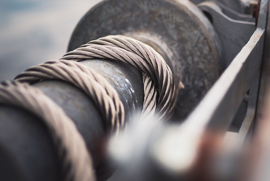 Detailed view of a strong steel cable wrapped around a mechanical reel, showcasing industrial strength.