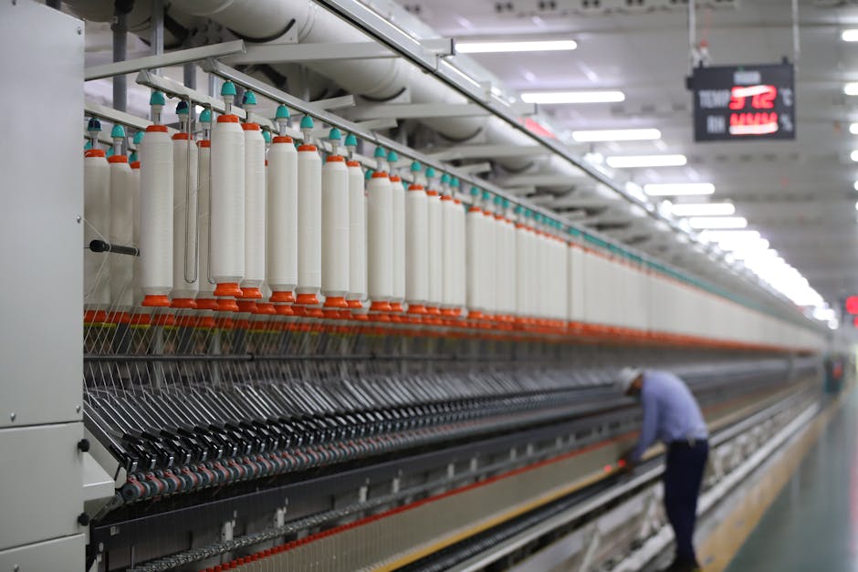 A textile factory in India showcasing modern spinning machinery with a worker.